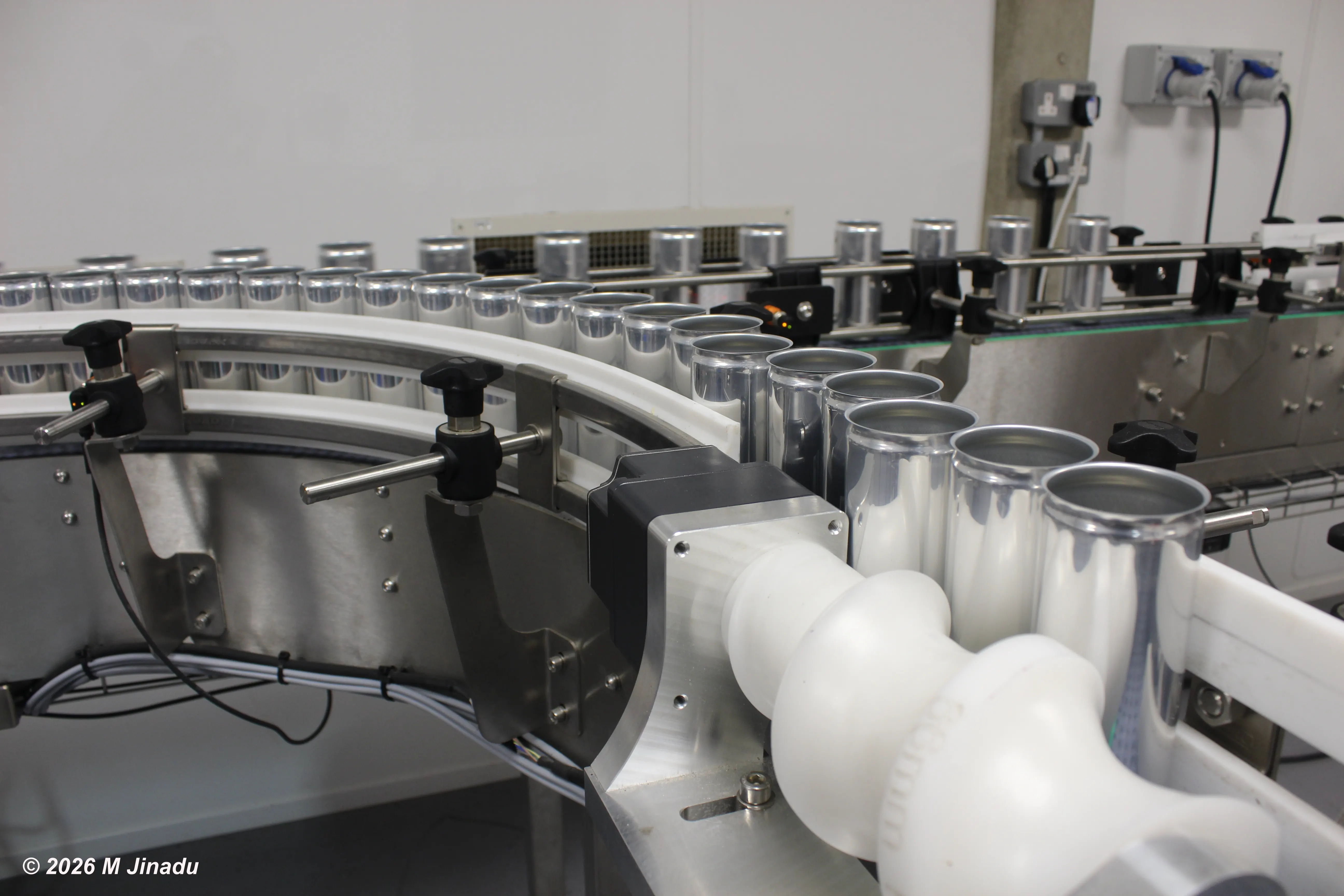 silver cans going through factory line